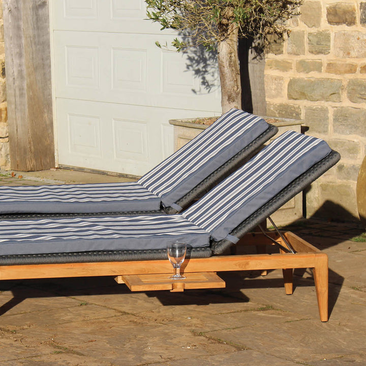 Close up of set of two Gustav teak sun loungers with Rhode Island striped Olefin pads
